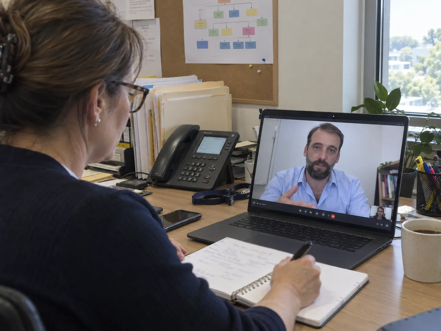 An HR director taking notes on a video discovery call with Damien Diecke