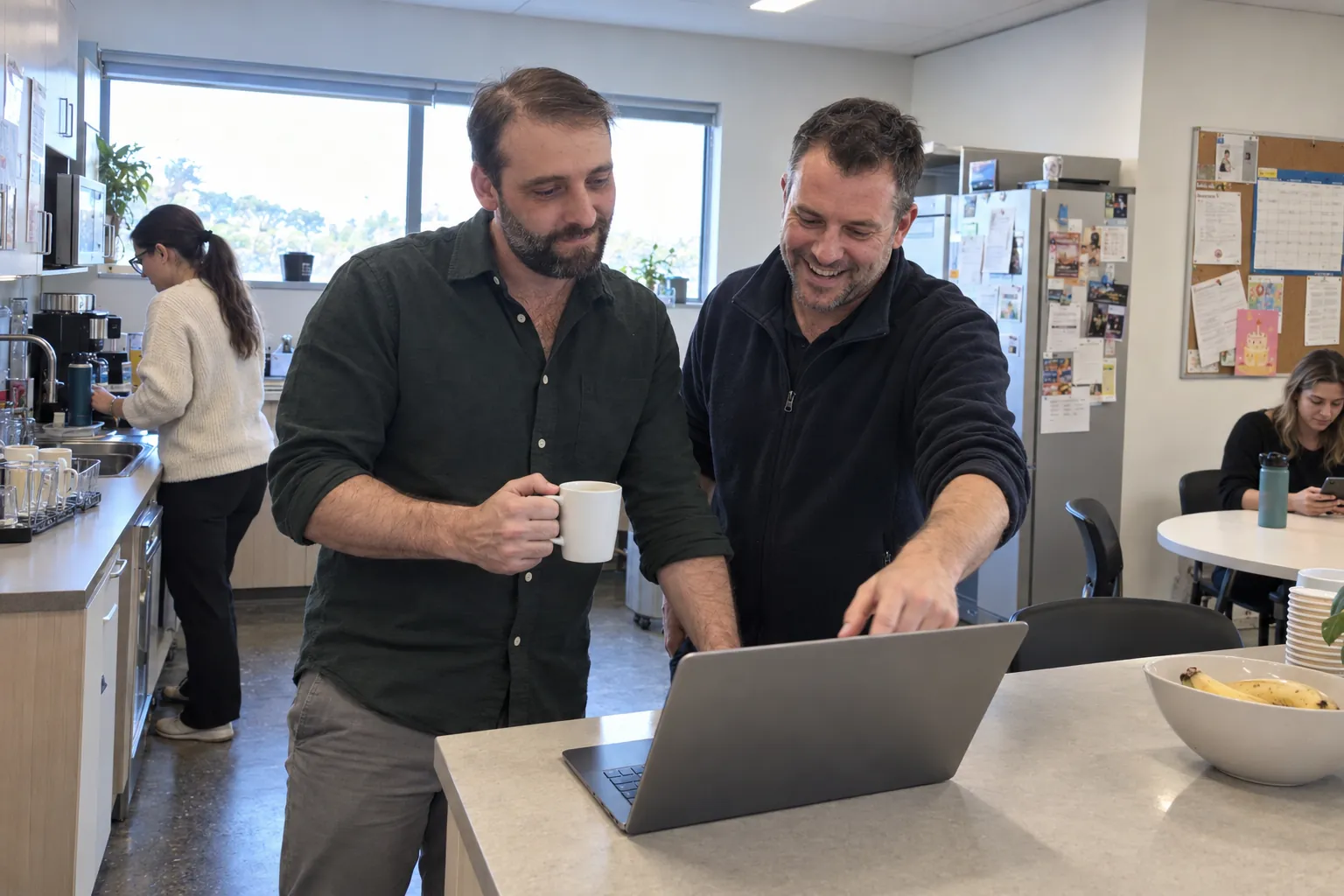 Damien Diecke reviewing a live automation’s dashboard with a client’s operations manager over coffee